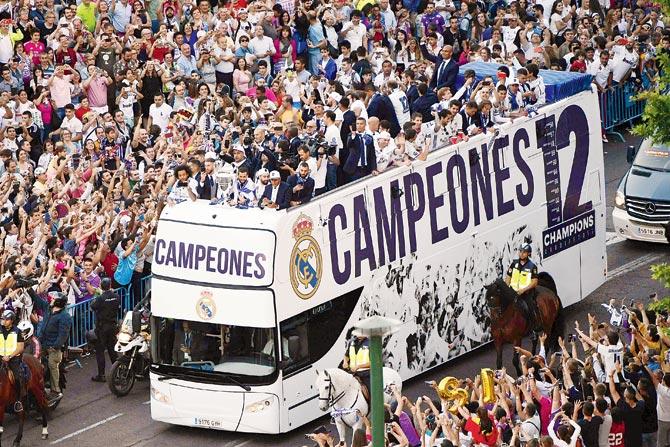Real fans surround the team bus during the Champions League  trophy parade in Madrid on Monday. Pic/AFP