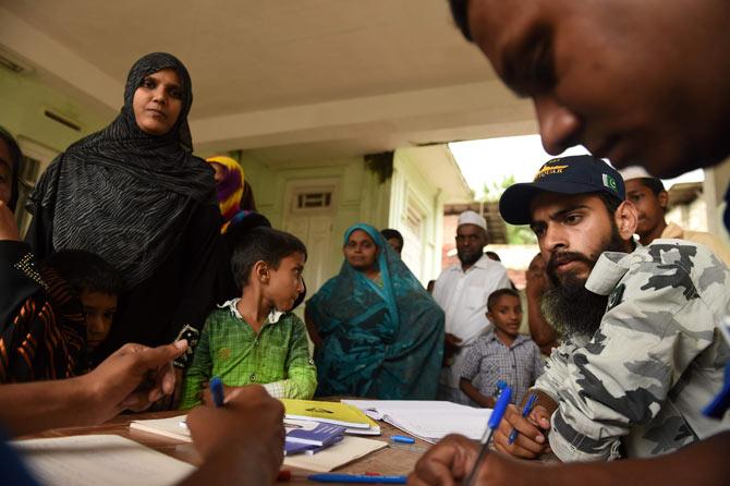 Sri Lankan and Pakistan navy medical staff attend to a flood victim at a refugee medical camp in Malwana. Pic/AFP