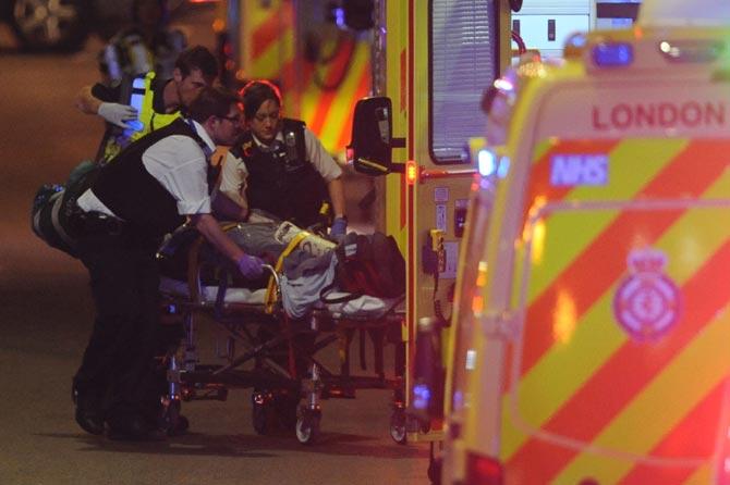 Police officers and members of the emergency services attend to a person injured in an apparent terror attack on London Bridge in central London