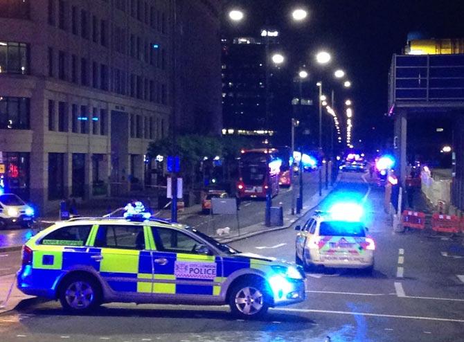 A photograph taken on a mobile phone shows British police cars blocking the entrance to London Bridge, in central London. Pic/AFP