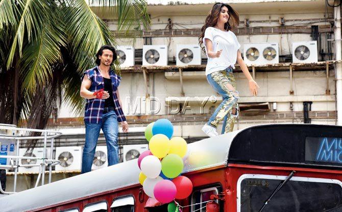 Taking inspiration from Malaika Arora’s yesteryear act on a train, Tiger Shroff puts his suave moves on display atop a BEST bus at an iconic Juhu cinema. His co-star Nidhhi Agerwal wins hearts with her playful act. Pic/Suresh Karkera, yogen shah