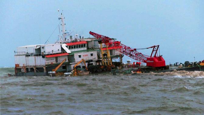 A Coast Guard ship carries out rescue works after a dredging barge hit rocks in the Arabian sea off Ullal coast near Mangalore on Saturday
