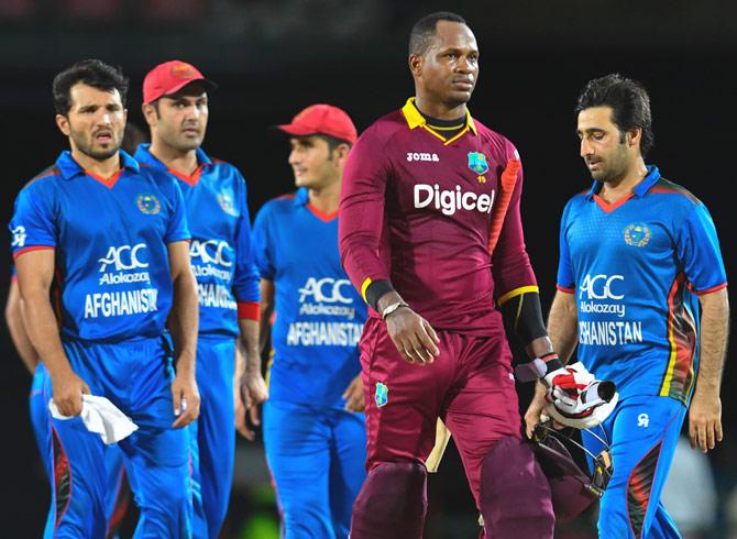 Mohamad Asghar Stanikzai (R) of Afghanistan watches as Marlon Samuels (2R) of West Indies walks off the field not out at the end of the 3rd and final T20i match between West Indies and Afghanistan at Warner Park, Basseterre, St. Kitts, June 05, 2017. Pic/AFP