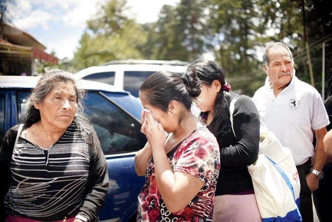 as a relative mourns . Pics/AFP