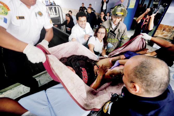 Volunteer, firefighters rescue a girl from a fire at the children’s shelter in Guatemala City