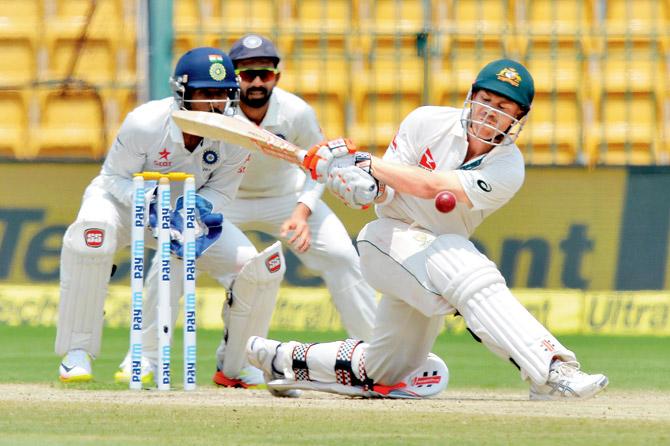 Australia opener David Warner is about to be dismissed leg before wicket while playing a sweep shot against India’s R Ashwin in the Bangalore Test on Tuesday. Pic/AFP
