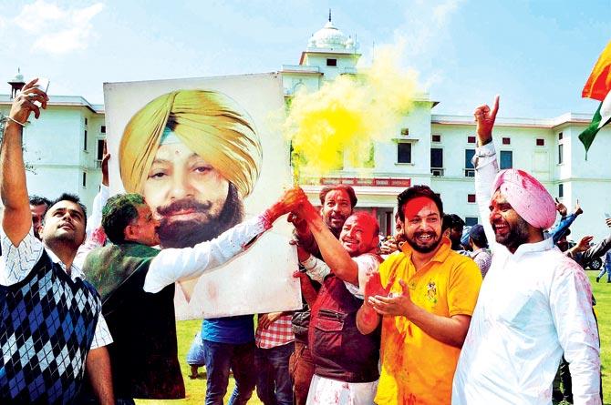 Congress workers celebrate outside Congress leader Captain Amarinder Singh