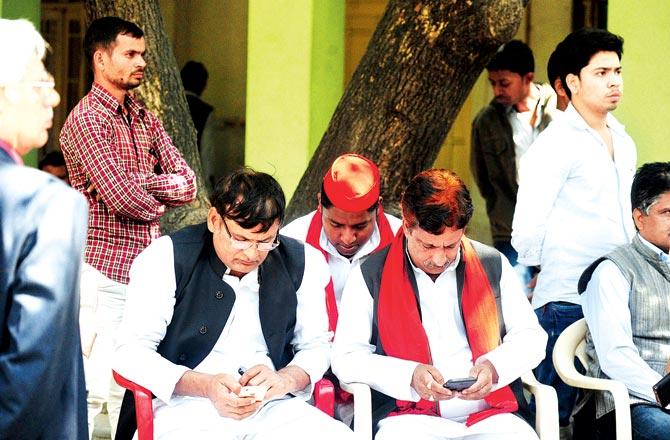 Dejected Samajwadi Party workers sit at their party office in Lucknow and discuss the party