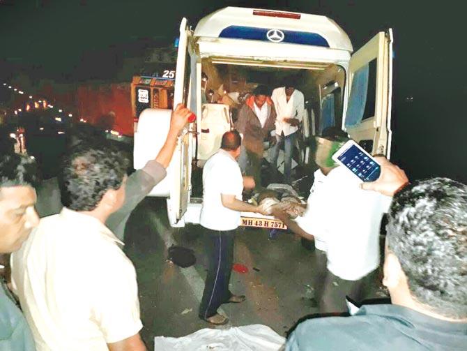 Rescuers bringing the bodies people out of the crushed bus