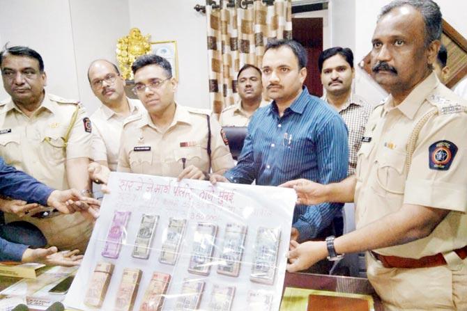 Deputy Commissioner of Police Manojkumar Sharma, Dilip Shinde, JJ Marg senior inspector, and his team with the recovered cash
