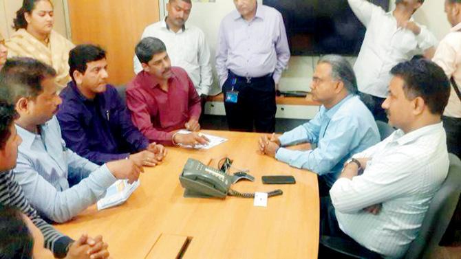MNS vice president Nayan Kadam (in maroon shirt) speaks to officials at Reliance Energy’s Dahisar office