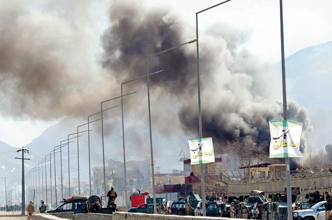 Smoke rises from an Afghan police district headquarters building after a suicide car bombing in Kabul on March 1,