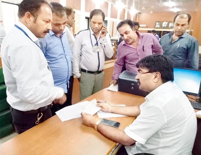 Deputy municipal commissioner Yuvraj Badane talks to civic officials about the auction at UMC headquarters. Pic/Navneet Barhate