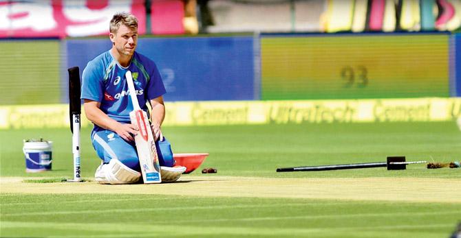 Australia opener David Warner meditates on the pitch during a practice session on the eve of the Bangalore Test recently. Pic/PTI