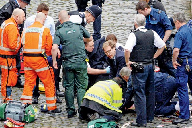 MP Tobias Ellwood performs CPR on the injured police officer outside the Houses of Parliament. Pic/AFP