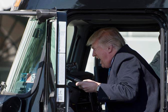 US President Donald Trump sits in the drivers seat of a semi-truck as he welcomes truckers and CEOs to the White House in Washington, DC. Photo/AFP