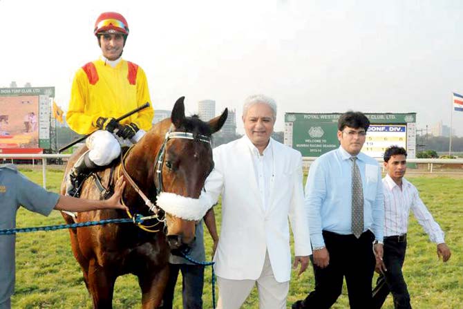 Jaydev Mody (right) leading in his horse at the racecourse