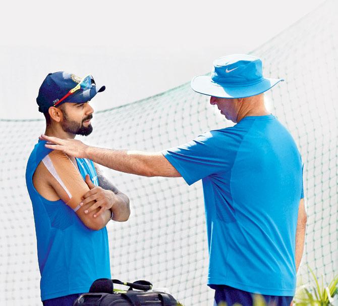  Virat Kohli with physiotherapist Patrick Farhart during a practice session in Dharamsala  yesterday. Pic/PTI