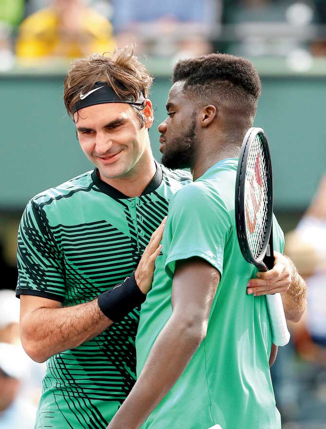 Roger Federer (left) greets Frances Tiafoe after their first round tie on Saturday. Pic/AFP