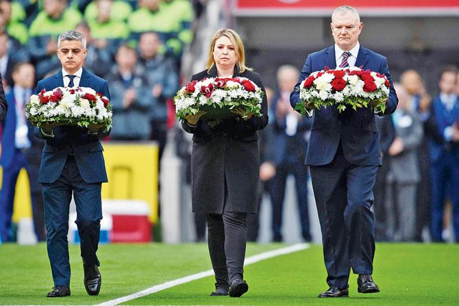 London mayor Sadiq Khan (left), Secretary of State for Culture, Media and Sport Karen Bradley and FA chairman Greg Clarke lay wreaths on the pitch for the victims of the Westminster attack yesterday. Pic/AFP