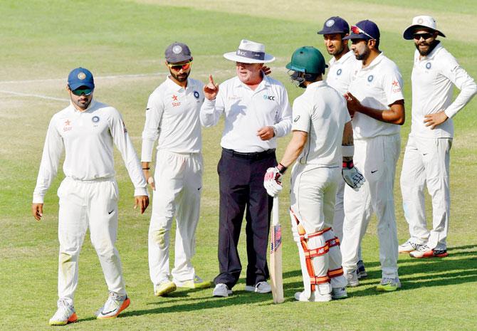 Umpire Ian Gould tries to calm things down after an altercation between Indian players and Aussie batsman Matthew Wade. Pic/PTI