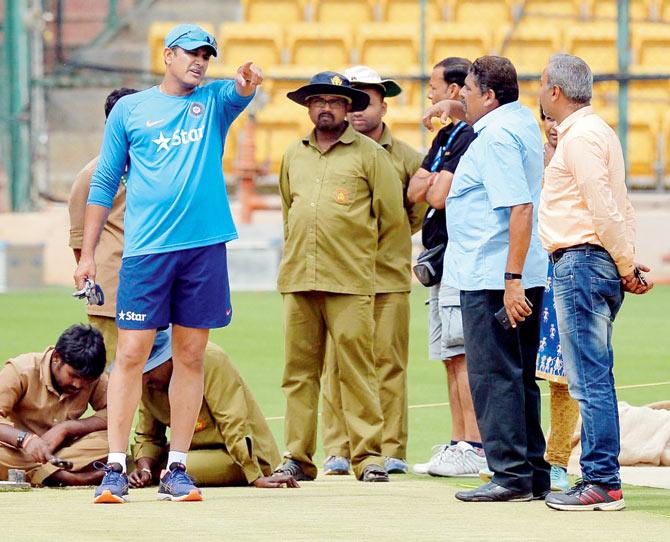 India head coach Anil Kumble (left) interacts with groundstaff yesterday at Chinnaswamy Stadium in Bangalore where the second Test versus Australia begins tomorrow. Pic/AFP