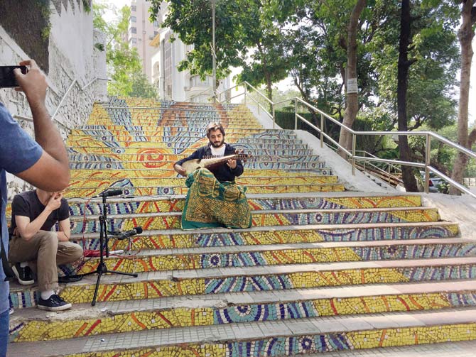 Sufi singer and self-taught rabab maestro Chintoo Singh Wasir plays the instrument on the steps of Mount Mary church
