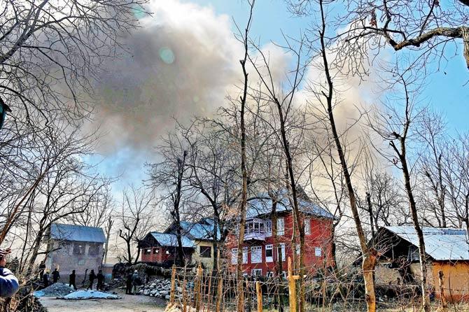 Smoke billows out of the house where the terrorists were holed up
