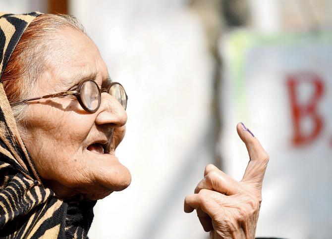 A woman displays an indelible ink mark on her finger after casting her vote at Varanasi. Pic/AFP