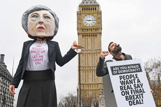 A demonstrator wearing a mask depicting Britain’s Prime Minister Theresa May protests against the UK’s triggering of Article 50, outside the Houses of Parliament in central London yesterday. Pic/AFP