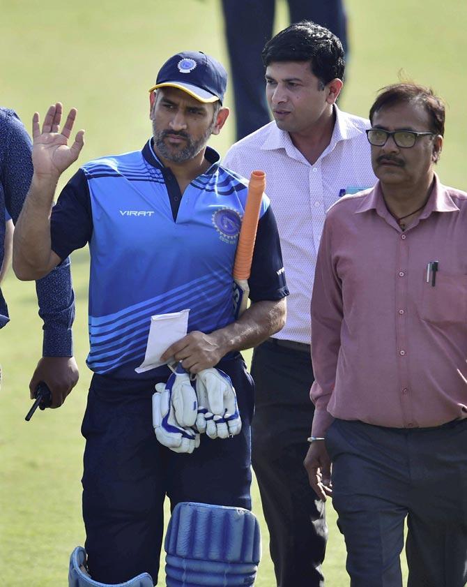 Jharkhand team captain M S Dhoni waves at crowd as he walks off the field after winning the Vijay Hazare trophy match against Vidarbha. Pic/PTI