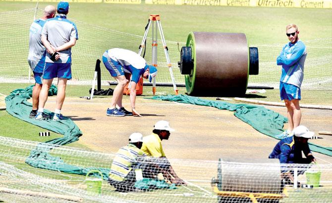 Australia captain Steven Smith inspects the third Test track support staff members look on in Ranchi yesterday. LEFT: India captain Virat Kohli during a practice session