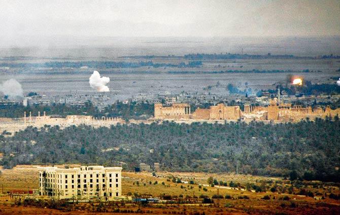 Smoke billows as Syrian regime fighters retake Palmyra. Pic/AFP