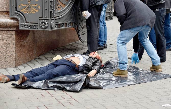 Ukrainian police experts look for evidence next to the body of former Russian MP Denis Voronenkov after he was shot dead. Pic/AFP