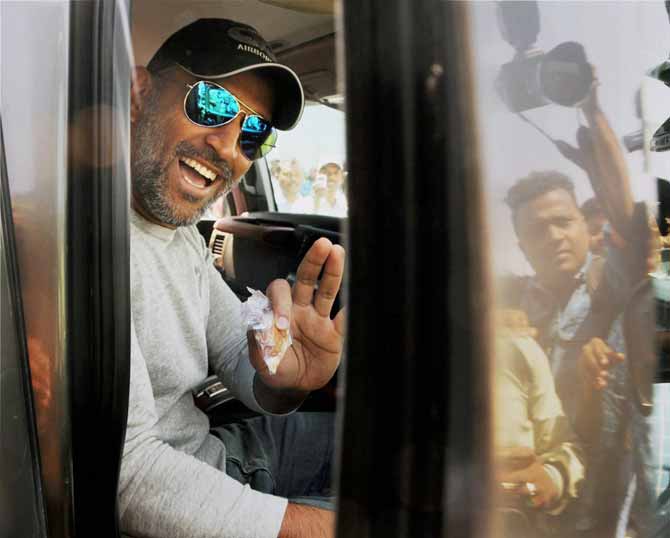 Mahendra Singh Dhoni waves at fans from his SUV after being spotted outside Ranchi