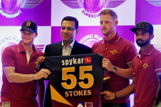 Rising Pune Supergiant captain Steve Smith (L), team owner Sanjiv Goenka (2L) and player Ajinkya Rahane (R) pose for a photograph with a team jersey as they welcome England