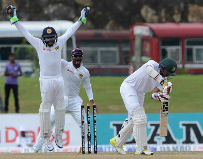 Sri Lankan wicketkeeper Niroshan Dickwella (L) and Dimuth Karunaratne (C) celebrates after he dismissed Bangladesh cricketer Soumya Sarkar (R) during the final day of the opening Test match between Sri Lanka and Bangladesh at the Galle International Cricket Stadium in Galle on March 11, 2017. 