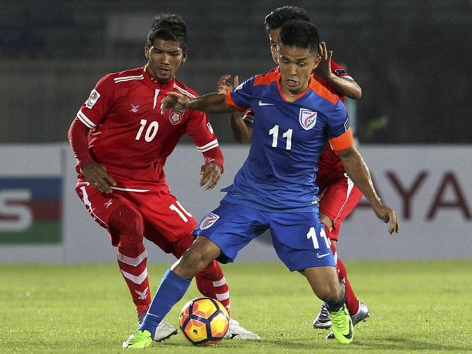 Sunil Chhetri, center, player of the India team, vies for the ball between Myanmar