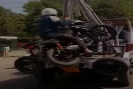 Bizarre Video! Traffic Police tow bike with owner after he refuses to get down 