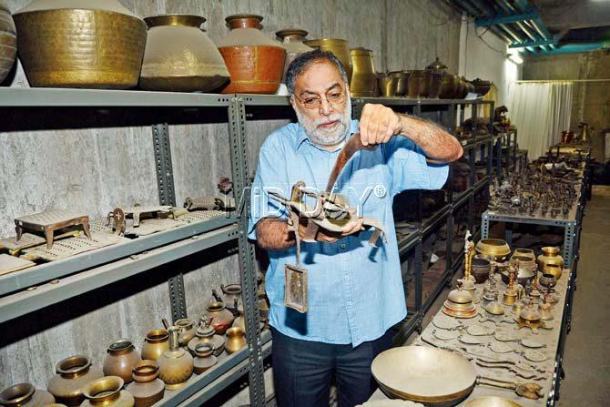Restaurateur Vithal Kamat holds a 400-year-old multi-purpose coconut shredder