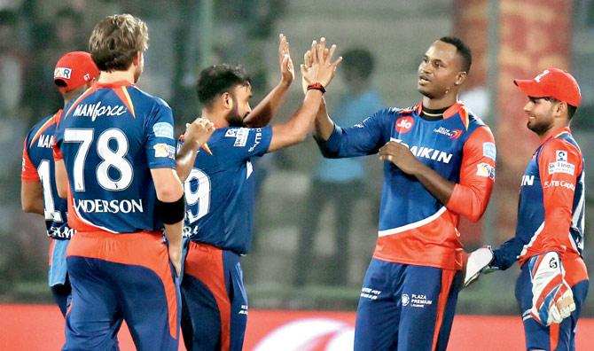 Delhi Daredevils players celebrate the fall of a Mumbai Indians wicket at the Kotla on Saturday. Pic/PTI