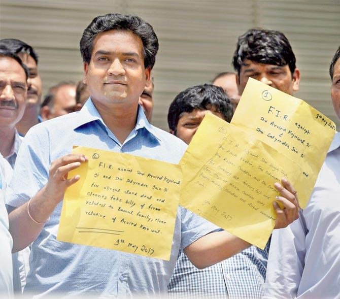 Sacked Delhi Minister Kapil Mishra shows copies of his complaint alleging irregularities in the AAP prior to approaching the CBI. Pics/PTI