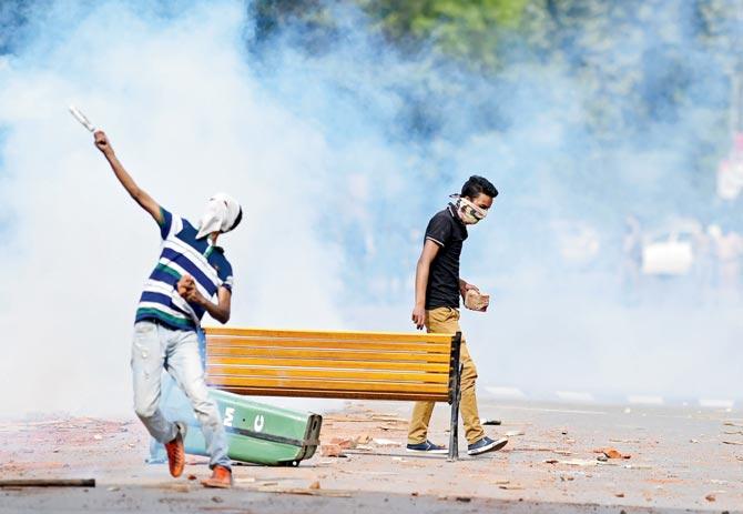 A Kashmiri student throws a teargas canister back towards security personnel in Srinagar’s Lal Chowk yesterday. Pic/AFP
