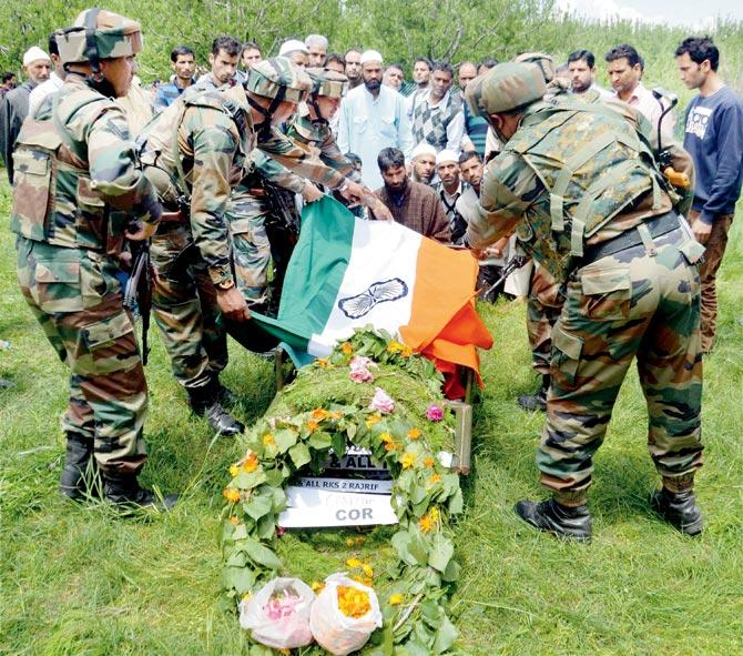 Army personnel pay tribute to slain Army officer Lt Ummer Fayaz as his family breaks down in Sudsona village, Kulgam district, Kashmir, yesterday. Pics/PTI