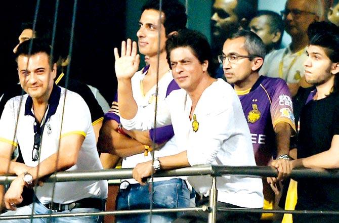KKR co-owner Shah Rukh Khan greets fans, while fellow actors Sanjay Kapoor and Sonu Sood look on during the IPL match vs Mumbai Indians in Kolkata on Saturday. Pic/PTI