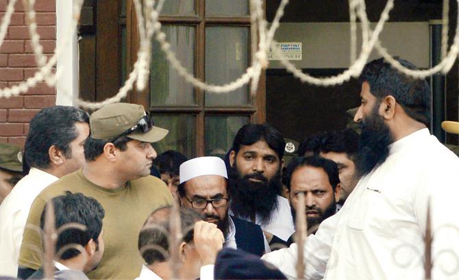 Police escort Hafiz Saeed to a court in Lahore. Pic/AFP