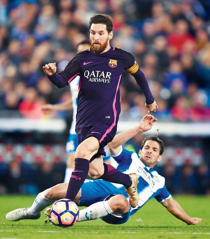 Barcelona’s Lionel Messi (left) is tackled by Espanyol’s Victor Sanchez during a La Liga match in Barcelona on Saturday. Pic/Getty Images