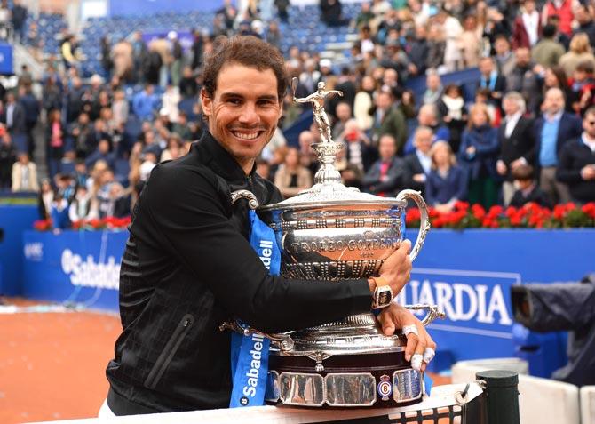 Spanish tennis player Rafael Nadal celebrates with his trophy after winning