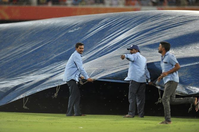 Grounds people cover the pitch with a tarp as rain stops play during the 2017 Indian Premier League (IPL) Twenty20 cricket match between Sunrisers Hyderabad and Kolkata Knight Riders. Pic/AFP