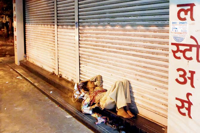 A homeless woman finds shelter outside a shut pharmacy near KEM Hospital in Parel. Pics /Pradeep Dhivar